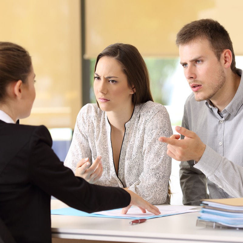 Young couple accusing a professional woman of negligence